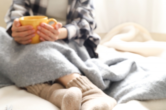 寒い日に家でじっとしている女性
